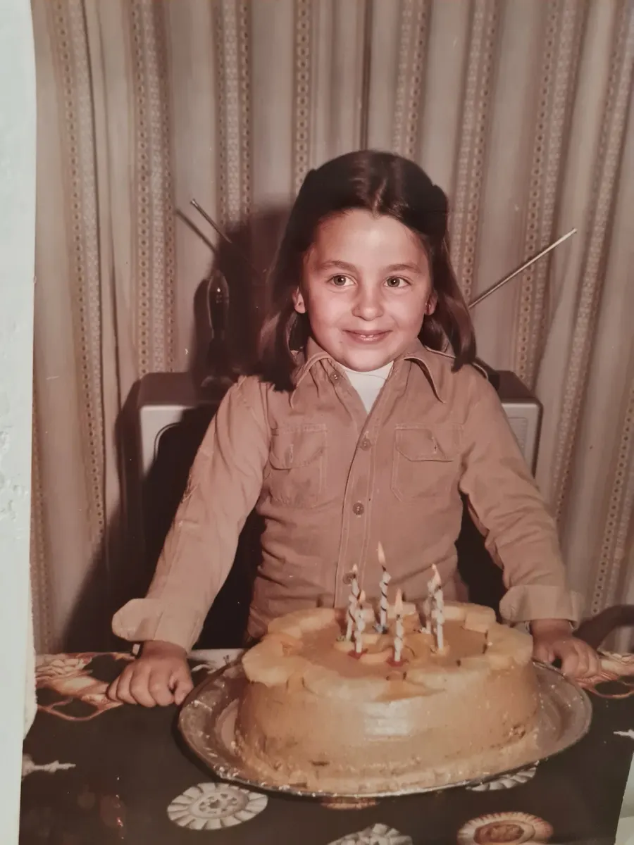 Gisela as a child, in front of a birthday cake